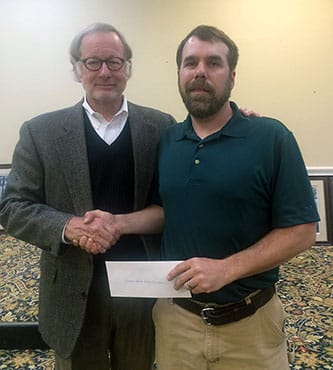 Brent Howze receives check from Bobby McKinney