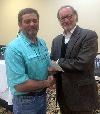 Clay Sisson receives check from Bobby McKinney