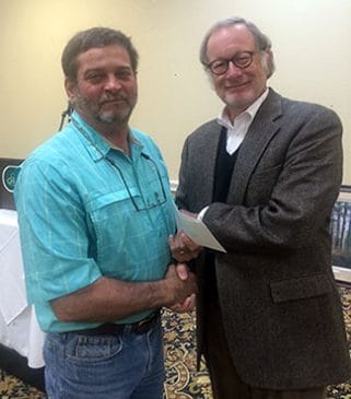 Clay Sisson receives check from Bobby McKinney