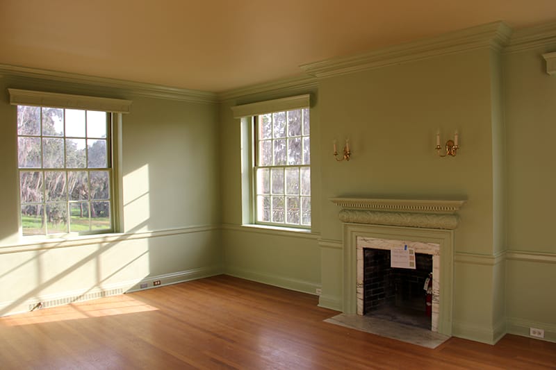 The second and third floor rooms were suffering extensive paint failure due to poor surface preparation and lack of an HVAC system. Once the HVAC system was installed, the interior surfaces were repaired, prepped properly, and repainted in the historic paint colors as determined by IFACS. The natural green tone in this bedroom complements the landscape around the house.